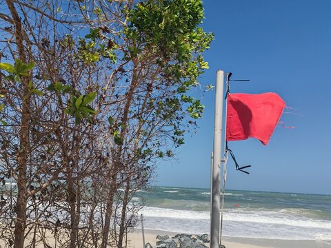 Red flag on a beach is No swimming sign.
Red flag on beach, which serves as a safety warning sign.
A red flags indicates high hazard conditions, such as strong surf, dangerous currents, or pollution.