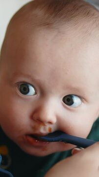 A baby eagerly focuses on a spoon. The baby s wide eyes reflect curiosity as the spoon approaches.