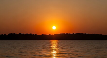 Obraz premium Sunset over the water with a beautiful orange sky.