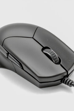A black computer mouse sitting on a clean white surface, perfect for illustrations and designs. vertical frame