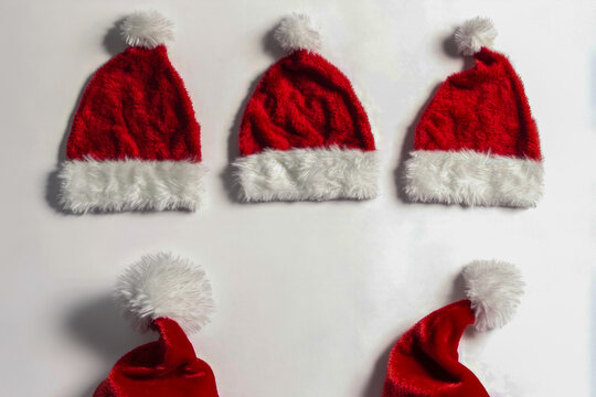 A stack of six colorful Santa hats in red and white. vertical frame