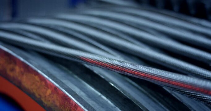 Close up of industrial steel wire rope wound on a large spool in a warehouse or manufacturing facility
