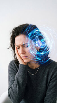 Woman suffering from tinnitus with glowing inner ear anatomy visualization. Pain and ringing in ear. Medical concept of hearing loss, vertigo, auditory system disorder and health problem.