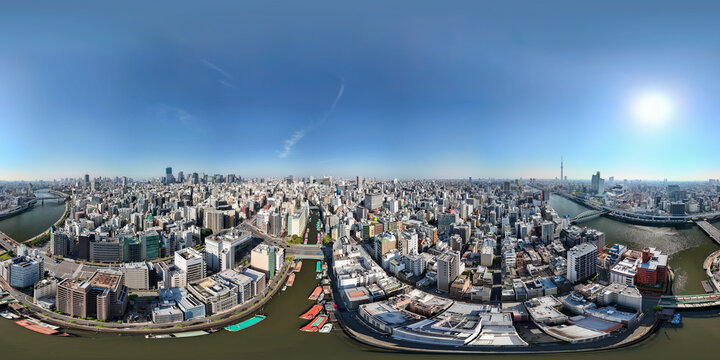 Full 360 degrees panorama of Tokyo skyline captured by drone over Sumida River in Yanagibashi, showcasing urban cityscape and clear skies