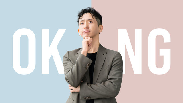OKかNGかを考える日本人男性ビジネスパーソンの判断イメージ, Japanese Businessman Thinking About OK or NG Decision