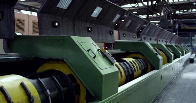 Close up of heavy industrial machinery in a row for steel wire rope production in a manufacturing plant