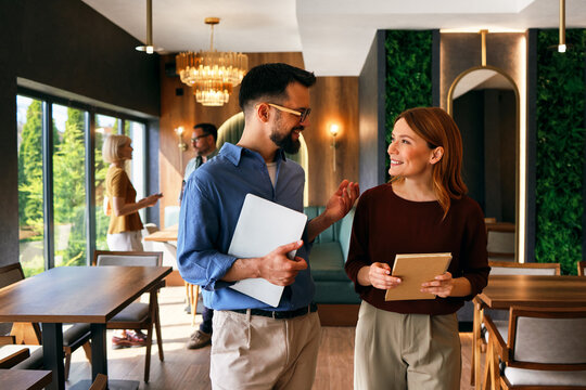 Business colleagues having casual conversation in modern cafe