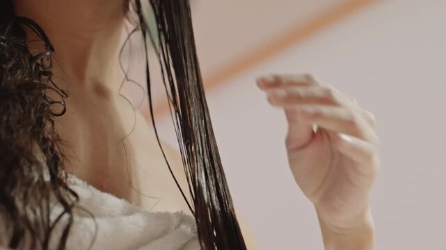 Gentle hair care. Softly styling delicate strands carefully. Tenderly unravel silky forelocks with gentle touch. An intimate moment of careful fingers working through smooth hair locks
