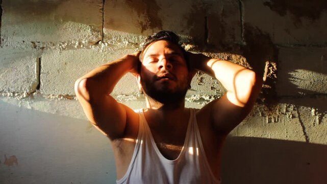 Portrait of a Colombian prisoner expressing frustration with his hands over his face against a wall inside a prison in Neiva, Huila, Colombia. Concept of justice and crime