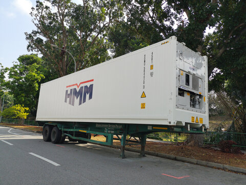 Refrigerated 40ft shipping container parked on a quiet city street, illustrating cold chain logistics, temperature-controlled transport, global trade, and supply chain operations