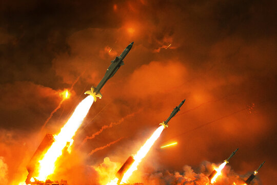 Dramatic night scene of a multiple rocket launcher system firing a massive barrage into the glowing orange sky. Intense fire, smoke, and powerful missiles illuminate the dark, smoky battlefield. War