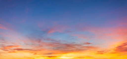 Fototapeta premium The skies at sunrise and sunset are breathtakingly beautiful, filled with colorful clouds and soft, gradual shades of blue,A breathtaking panoramic view of the evening sky during sunset, featuring.