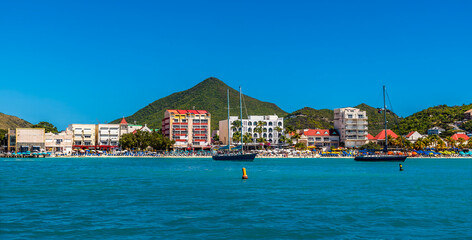 A view past boats moored towards the centre of the Great Bay Beach in Philipsburg, Sint Maarten on a sunny day