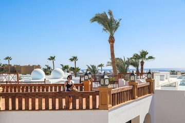 Fototapeta premium Traveler Woman Enjoying Breathtaking Sea View from Spacious Balcony of Egyptian Hotel, Embracing the Serenity of Nature.