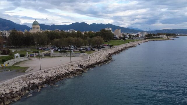 Aerial coastal city with park, breakwater, and Saint Andrew church dome