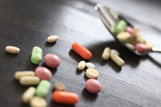 pills scattered on a dark background, medical topic dosage of medicine, concept of stress medicine