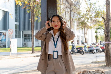 Obraz premium Asian businesswoman working on digital tablet with stylus outside modern building