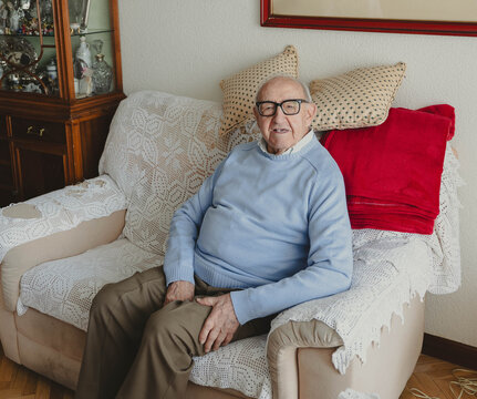 Senior man relaxing on armchair in living room