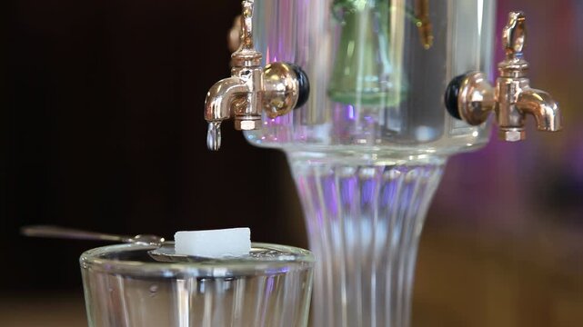 Hand closing absinthe fountain during traditional preparation ritual