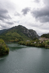 The sight of a river emerging from a deep, green valley on a cloudy day. © Güven CAN