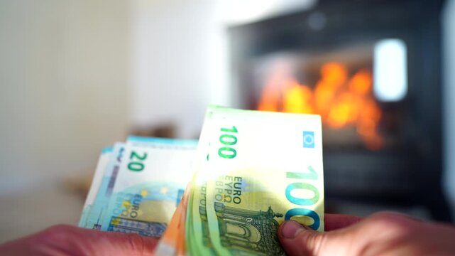 Heating payment. Save money wood stove. Euro money banknotes for payment of heating firewood. Budget wood heat home. Euro money pay for heating costs in heating season. Heat house in European Union EU