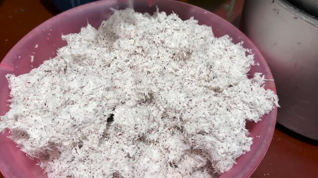 Pile up the clean coconut dregs in a bowl, the coconut dregs extract is then processed into coconut milk. Horizontal video 4K.