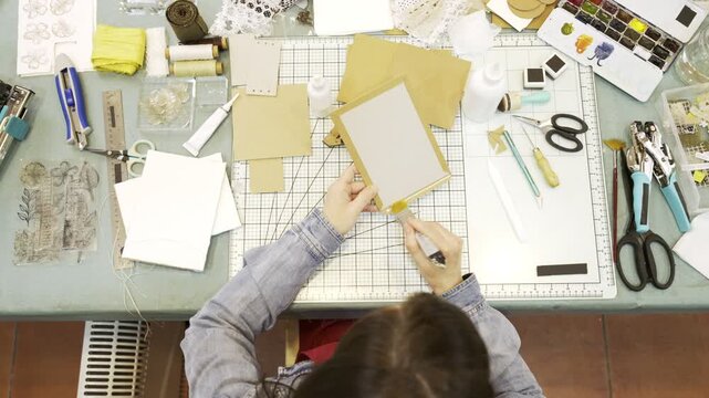Overhead view of a woman creating a handmade scrapbook album