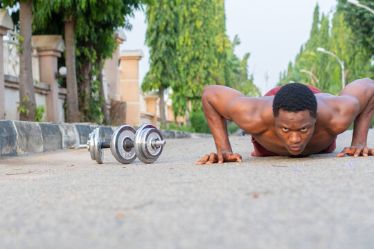 Muscular man showcasing strength by doing onehanded pushups