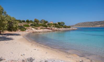 Obraz premium Agia Dynami Beach in Chios island, Greece. Sandy beach with emerald color waters and a chapel, blue summer sky