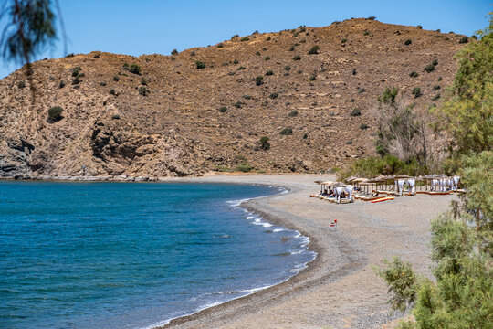 Agia Markella Beach turquoise waters and rocky hills under bright midday sun on Chios Island, Greece