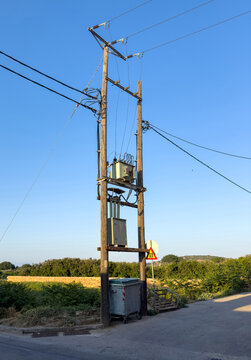 Tall wooden utility pole with electrical transformer at quiet rural road junction in Chios island, Greece