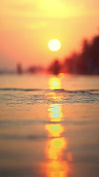 Golden sunset over tropical beach shore with gentle sea waves reflecting warm sunlight. A minimalist abstract concept of summer vacation, wellness, and peace of mind, perfect for travel backgrounds