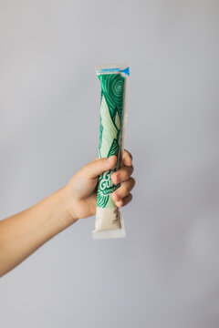 a boy holding one simply yogurt gogurts tube in his hand with beautiful green wrap 