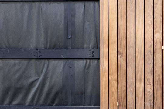 Front view of Exterior wood cladding installation on building wall with insulation under construction