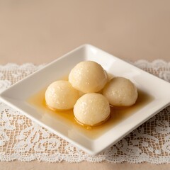 Fototapeta premium Indian Rasgulla or Rosogulla dessert/sweet served in a square bowl. selective focus
