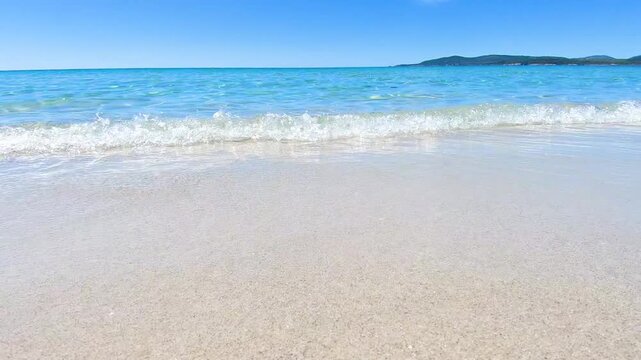 Ground level view of a beach foreshore with sand and gentle waves coastal nature travel scenic outdoor environment