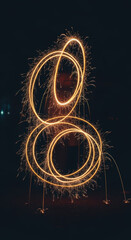 Bright golden sparklers form overlapping circular light trails against dark night background, creating festive bokeh magic and warm glowing motion