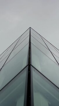 Vertical video: Camera tilting up, corner mullion and glass panels converging into apex for design
