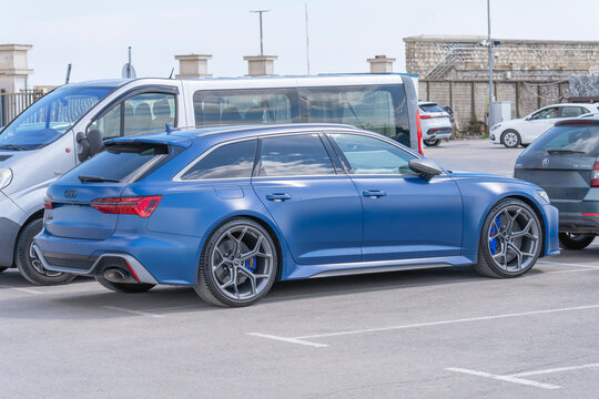 High-performance blue Audi RS6 Avant station wagon parked in an outdoor lot. This matte-finish sport wagon features aggressive styling, large alloy wheels, and blue brake calipers