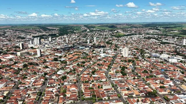 Aerial video footage of a vibrant city with red roofs under a blue sky