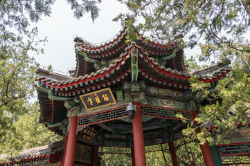 Fototapeta premium A low-angle view captures the intricate red, green, and gold painted details of an ornate traditional pavilion at the Summer Palace in Beijing, China - 27 May 2025