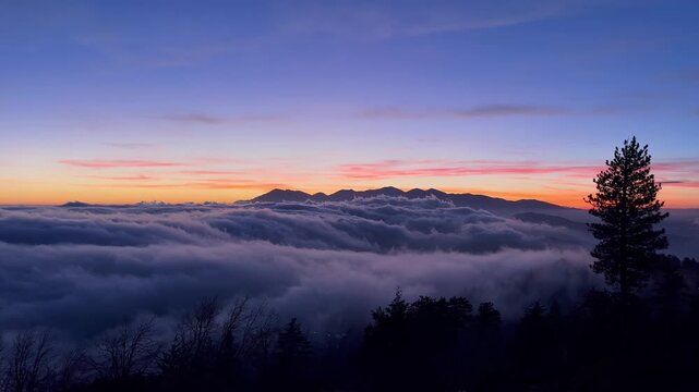 Blue hour fog rolling over the mountains at sunset