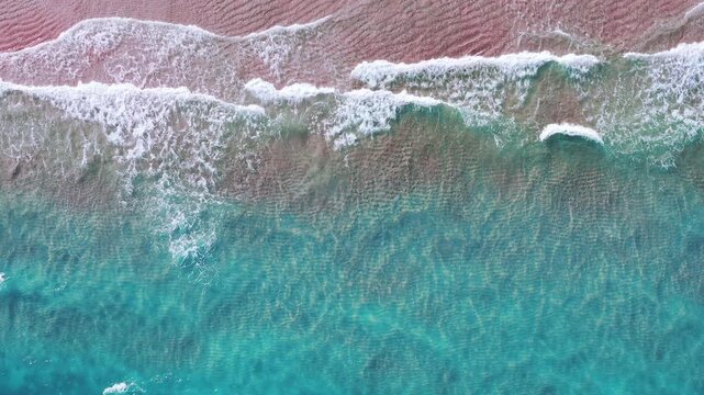 Pink sand and Turquoise waves on a tropical paradise beach.