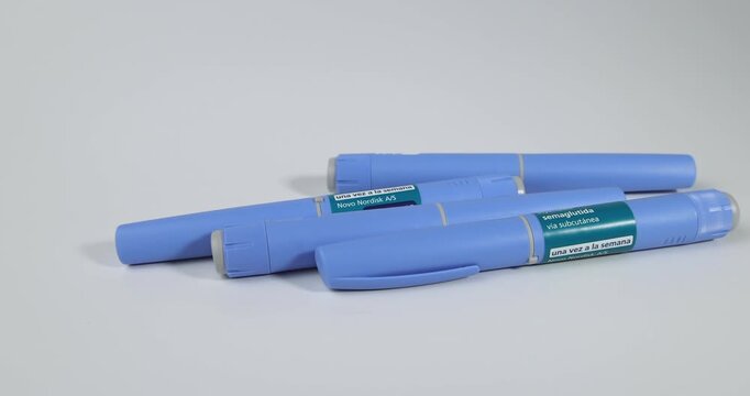 Cinematic panning over semaglutide glp-1 pens for morbid obesity and diabetes type 2 therapy on white for representing pharmaceutical care.