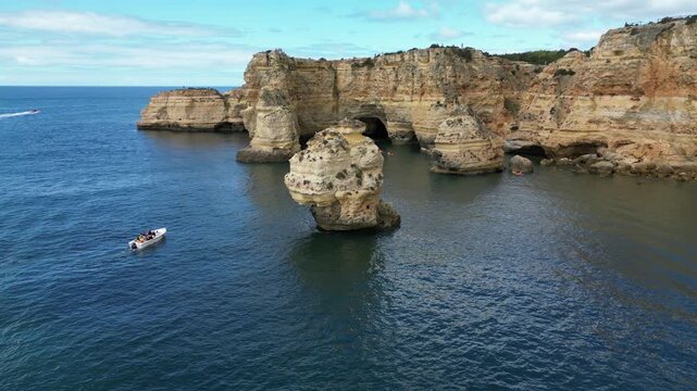 Aerial view of coastline with layered limestone cliffs, green hilltops and clear ocean water. Perfect for destination marketing and scenic travel content.