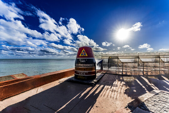 Iconic Southernmost Point buoy in Key West, Florida Keys, with dramatic sunlight and ocean backdrop, marking the southernmost location of the continental United States near Cuba
