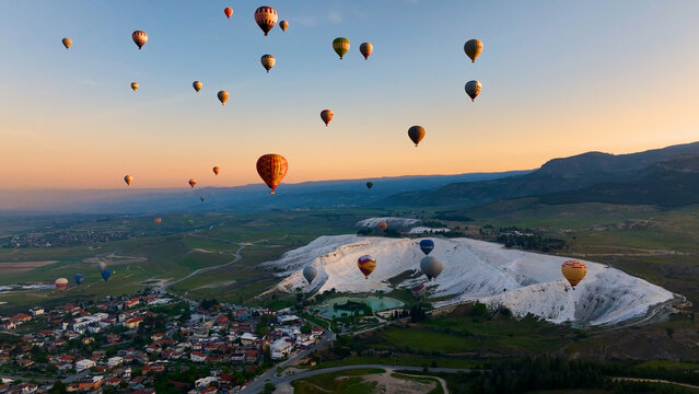 Hot air balloons and Natural travertine pools at sunrise in Pamukkale, 