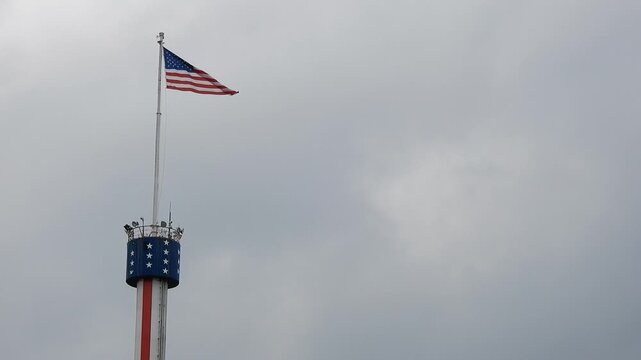 American Flag on Tower Waves in Wind on Cloudy Day