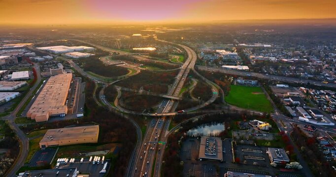 Moving over the multi-lane highway leading to the interchange. Scenery of New York suburbs at sunset time.
