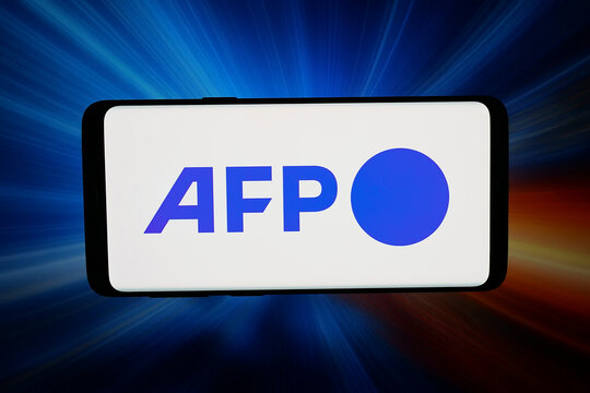 Stuttgart, Germany - 03-31-2026: In this photo illustration, the logo of French news agency Agence France-Presse (AFP) is displayed on a smartphone in front of abstract background on computer screen.
